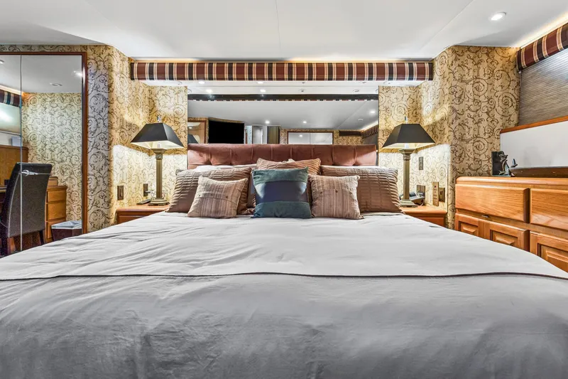 Slide: The Image of Luxurious bedroom interior on 1998 Viking 72 Enclosed Bridge yacht, featuring elegant decor and plush bedding. - 16