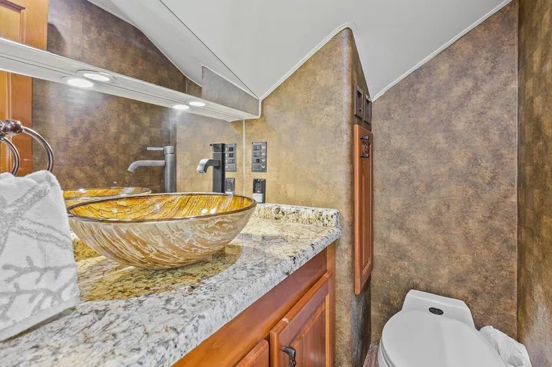 Slide: The Image of Luxurious bathroom in 1998 Viking 72 Enclosed Bridge yacht with vessel sink and granite countertop. - 17