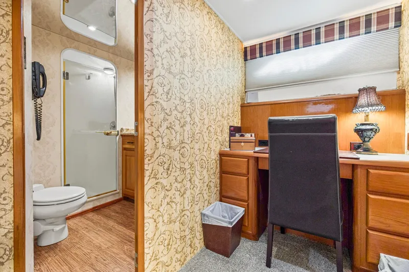 Slide: The Image of Interior of 1998 Viking 72 Enclosed Bridge yacht with desk, chair, and bathroom. - 18