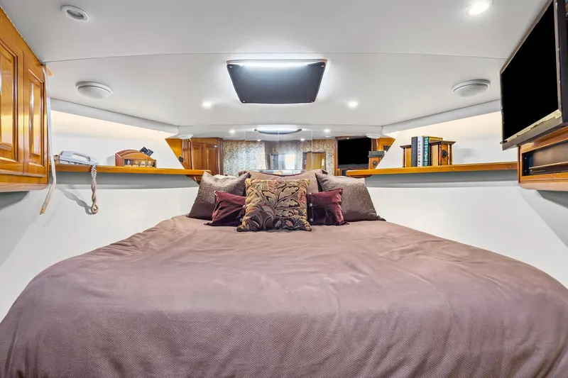 Slide: The Image of Luxurious bedroom interior of 1998 Viking 72 Enclosed Bridge yacht with cozy bedding. - 22