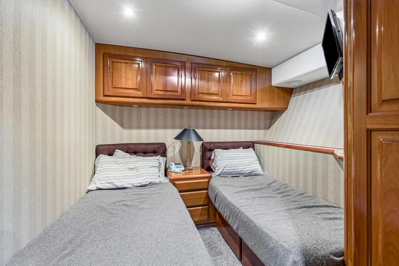 Slide: The Image of Cozy twin cabin interior of 1998 Viking 72 Enclosed Bridge yacht with wood cabinetry. - 23