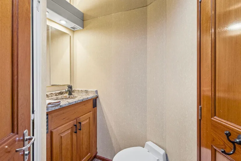 Slide: The Image of Bathroom interior of 1998 Viking 72 Enclosed Bridge yacht with wooden cabinetry and granite countertop. - 25