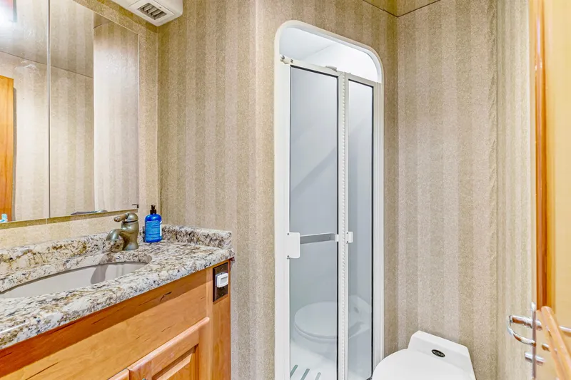 Slide: The Image of Luxurious bathroom in 1998 Viking 72 Enclosed Bridge yacht with granite countertop and shower. - 26