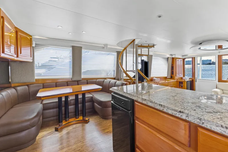 Slide: The Image of Luxurious interior of 1998 Viking 72 Enclosed Bridge yacht with elegant seating and spiral staircase. - 8