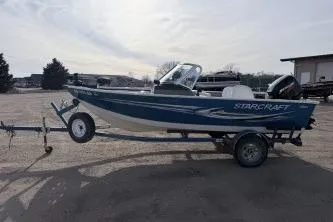 Slide: The Image of 2009 Starcraft Starfire 1600 DC boat on trailer, parked outdoors. - 2