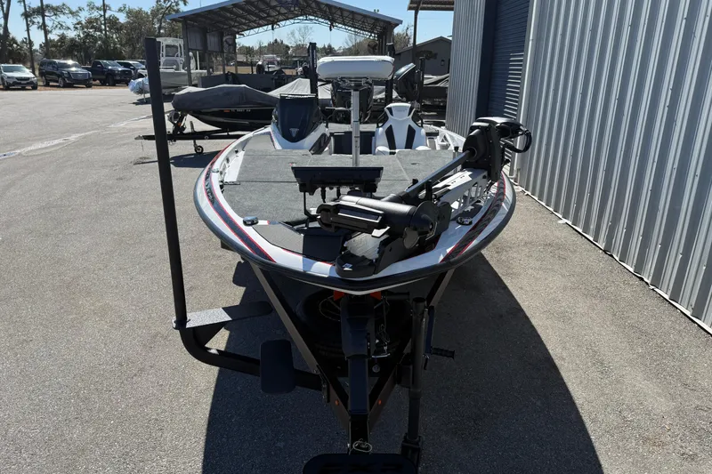 Slide: The Image of 2026 Skeeter FXR20 Apex boat parked outdoors near a metal building. - 1