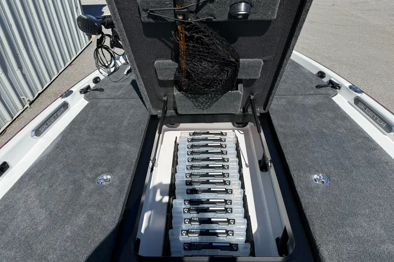 Slide: The Image of 2026 Skeeter FXR20 Apex boat storage compartment with organized tackle boxes. - 3