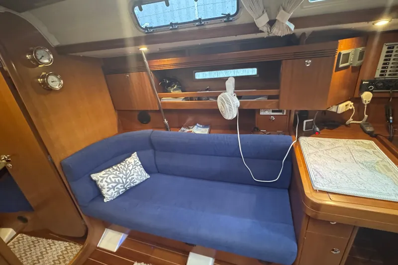 Slide: The Image of Interior of 2004 Dufour 40 Performance yacht with blue sofa and navigation table. - 11