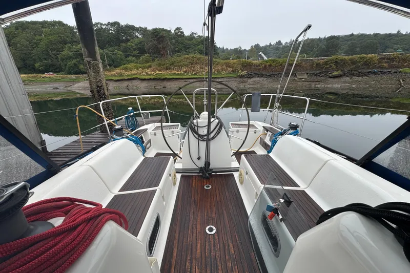 Slide: The Image of Cockpit view of 2004 Dufour 40 Performance sailboat docked by a serene shoreline. - 19