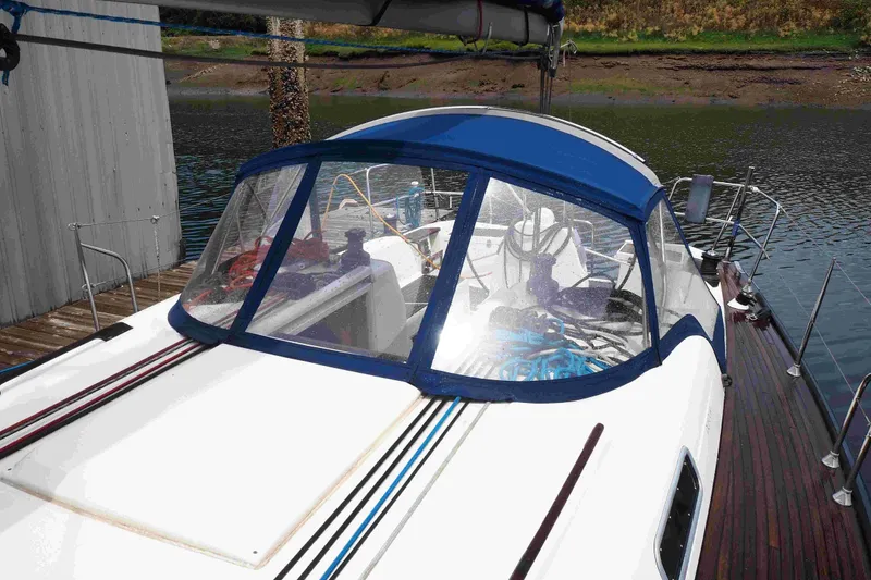 Slide: The Image of 2004 Dufour 40 Performance sailboat docked, featuring a blue canopy and sleek design. - 32
