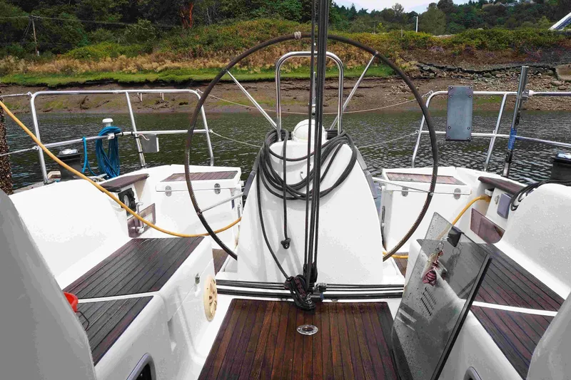 Slide: The Image of Cockpit of 2004 Dufour 40 Performance sailboat with wooden seating and steering wheel. - 33