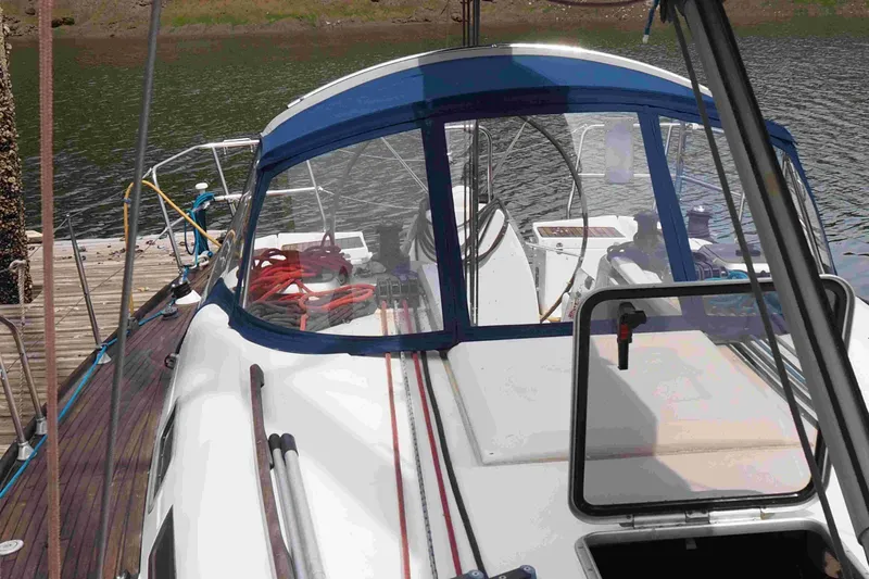 Slide: The Image of 2004 Dufour 40 Performance sailboat docked, featuring a blue canopy and wooden deck. - 46