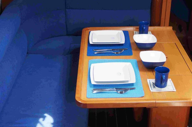 Slide: The Image of Dining setup on a 2004 Dufour 40 Performance yacht with blue seating and tableware. - 48