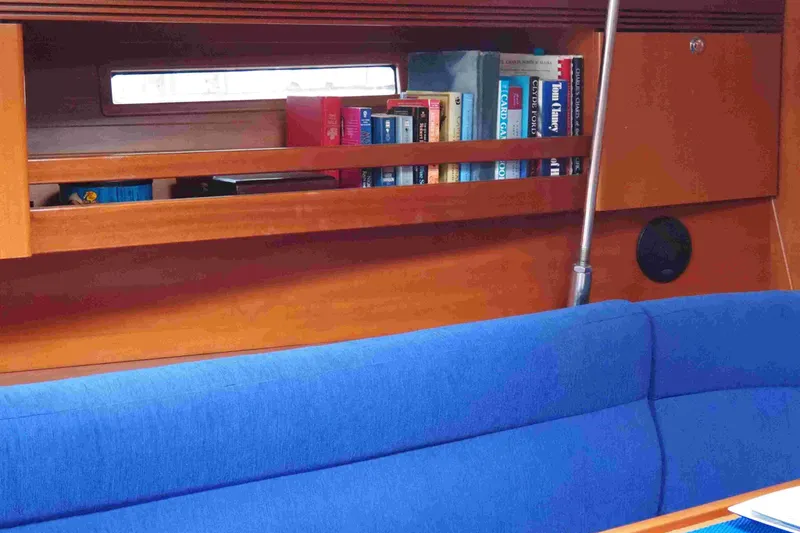 Slide: The Image of Interior of 2004 Dufour 40 Performance yacht with bookshelf and blue seating. - 50