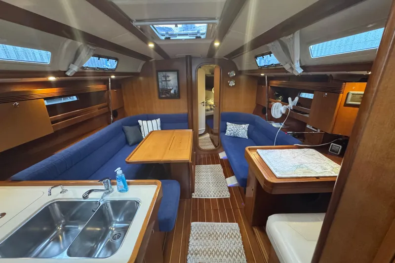 Slide: The Image of Interior of 2004 Dufour 40 Performance yacht with blue seating and wooden finishes. - 8