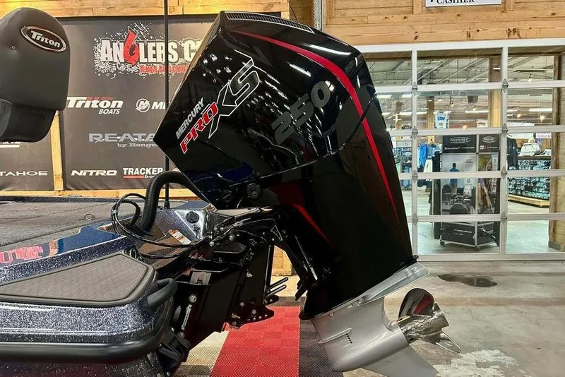 Slide: The Image of 2026 Triton 20XP Patriot with Mercury Pro XS engine displayed indoors. - 3