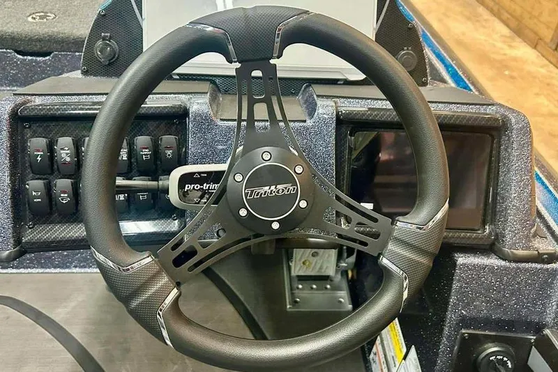 Slide: The Image of Steering wheel of 2026 Triton 20XP Patriot boat with control panel. - 5