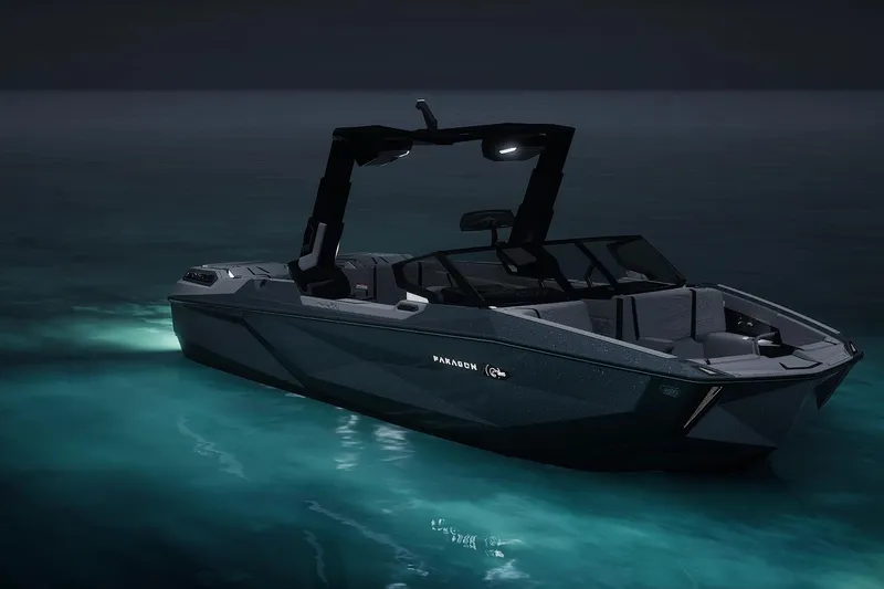 Slide: The Image of 2026 Nautique Super Air Nautique G25 Paragon boat illuminated on calm water at night. - 11