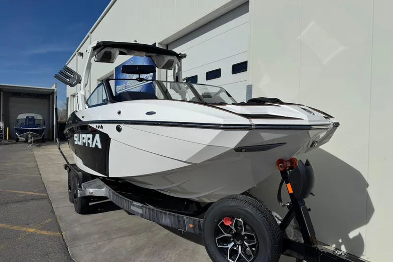 Slide: The Image of 2026 Supra SL 575 boat on trailer, parked outside a building. - 4