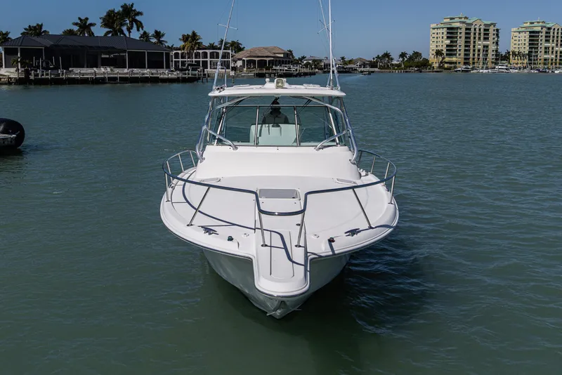 Slide: The Image of 2010 Scout 350 Abaco boat on calm water, with coastal buildings in background. - 2