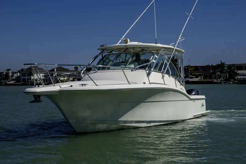 Slide: The Image of 2010 Scout 350 Abaco boat cruising on calm waters under clear blue sky. - 38
