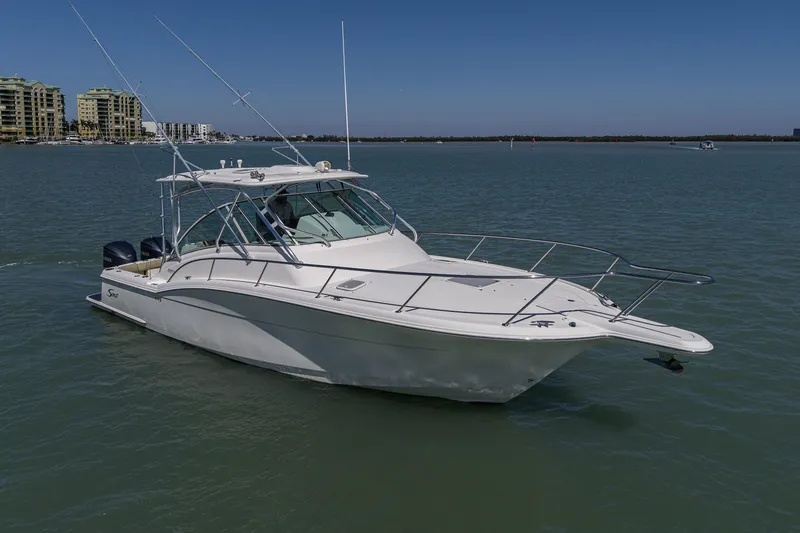 Slide: The Image of 2010 Scout 350 Abaco boat on calm water with cityscape background. - 4
