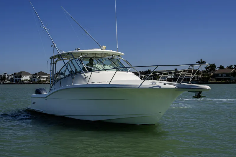 Slide: The Image of 2010 Scout 350 Abaco boat cruising on a sunny day near waterfront homes. - 41