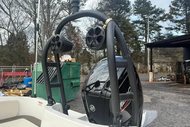 Slide: The Image of 2021 Bayliner Element E18 boat with speakers and motor, parked outdoors. - 11