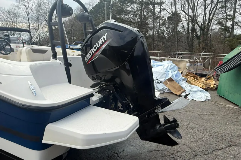 Slide: The Image of 2021 Bayliner Element E18 boat with Mercury outboard motor, parked outdoors. - 12