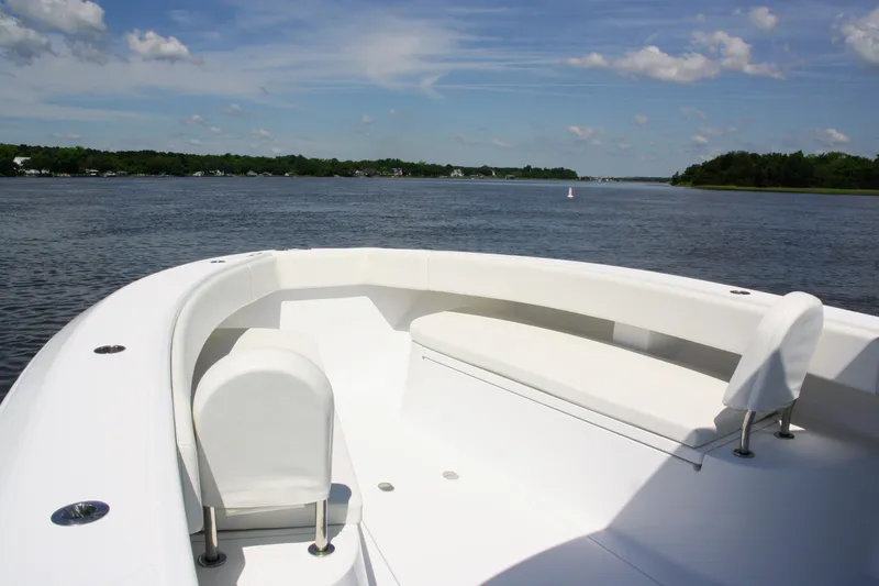 Slide: The Image of 2019 Bahama 41 boat with white seating, cruising on a calm river under a blue sky. - 10