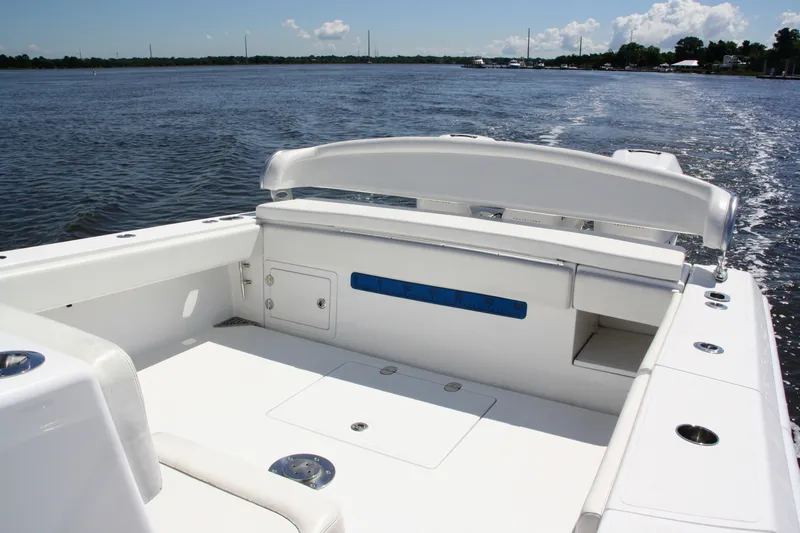 Slide: The Image of 2019 Bahama 41 boat interior with white seating, on calm water under a clear sky. - 12