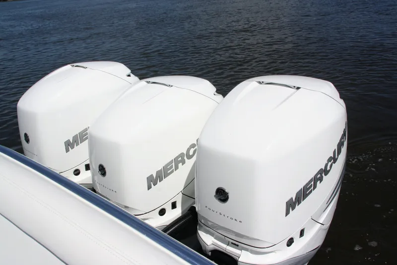 Slide: The Image of Triple Mercury outboard engines on a 2019 Bahama 41 boat in water. - 14