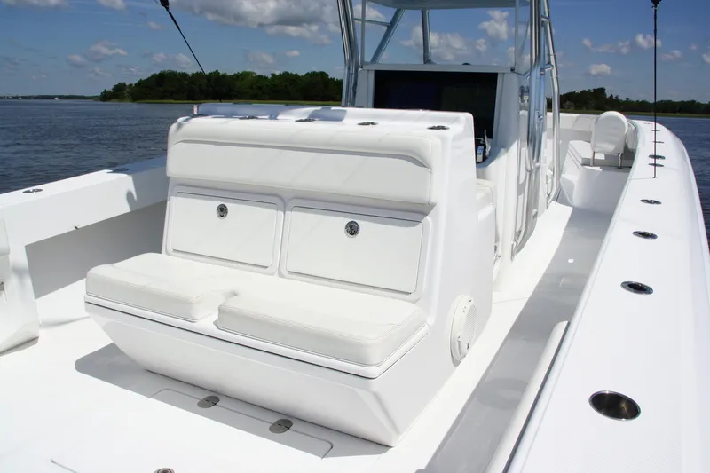 Slide: The Image of 2019 Bahama 41 boat with white seating, sleek design, and spacious deck on a sunny day. - 15