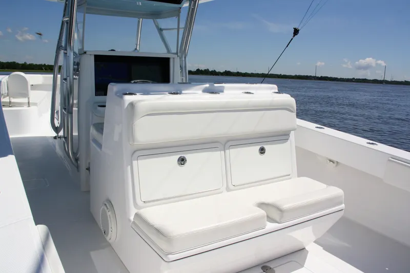 Slide: The Image of 2019 Bahama 41 boat interior with white seating and storage, on calm water. - 16