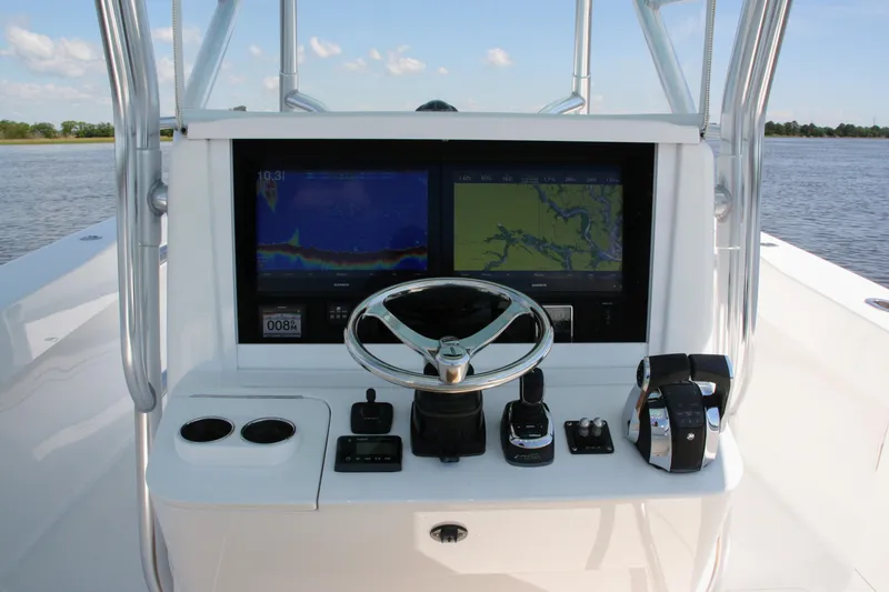 Slide: The Image of Control panel of a 2019 Bahama 41 boat with navigation screens and steering wheel. - 18