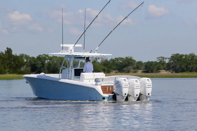 Slide: The Image of 2019 Bahama 41 boat with triple engines cruising on a calm lake. - 2