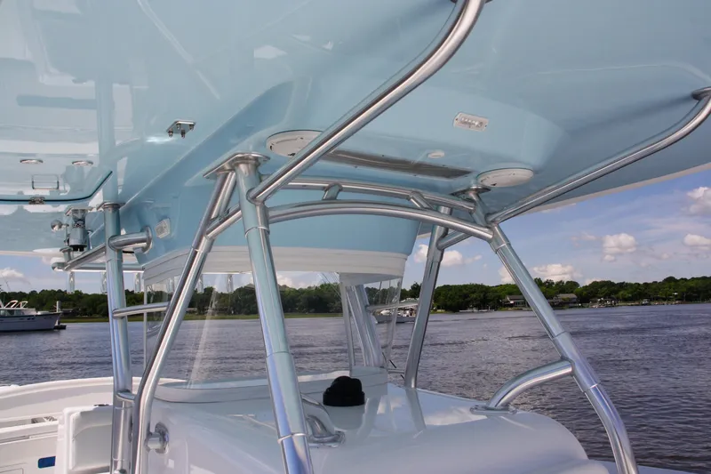 Slide: The Image of 2019 Bahama 41 boat with sleek blue canopy and stainless steel supports on a calm waterway. - 28