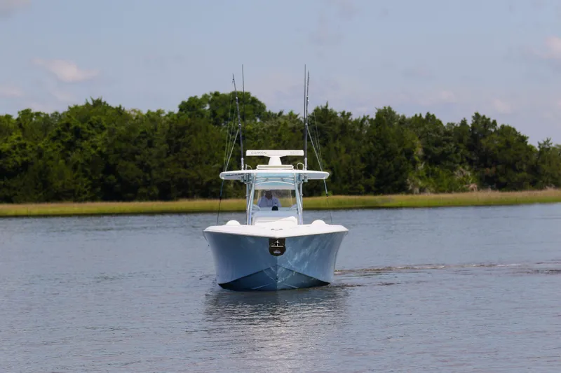 Slide: The Image of 2019 Bahama 41 boat cruising on a calm lake with lush green trees. - 7