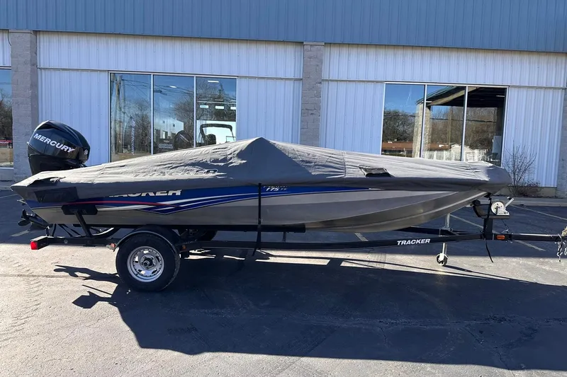 Slide: The Image of 2011 Tracker Pro Team 175 TF boat with cover on trailer, parked outside a building. - 27
