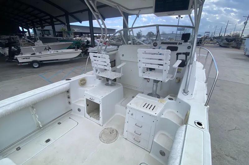 Slide: The Image of 2006 Polar 2300 Walkaround boat interior with seating and control panel in a marina setting. - 13