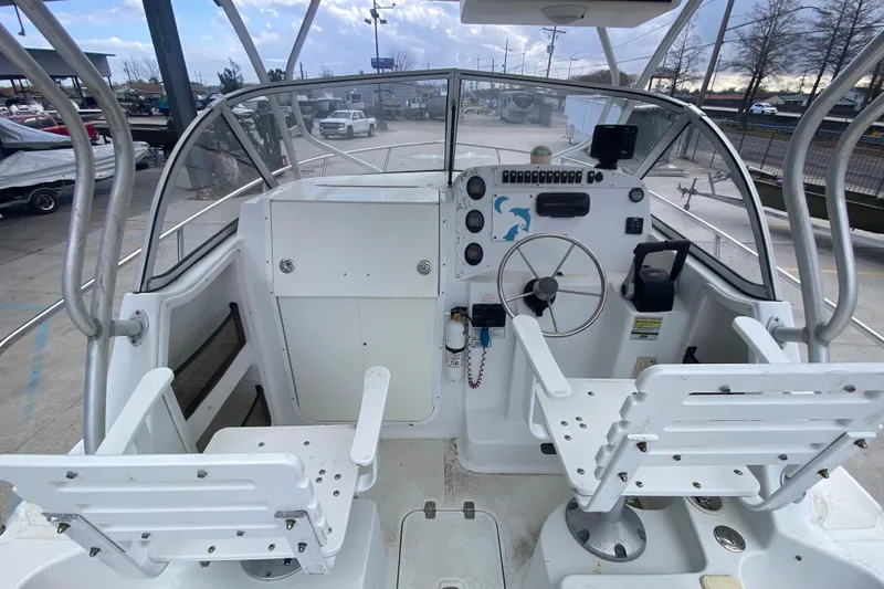 Slide: The Image of 2006 Polar 2300 Walkaround boat cockpit with dual white seats and steering wheel. - 14