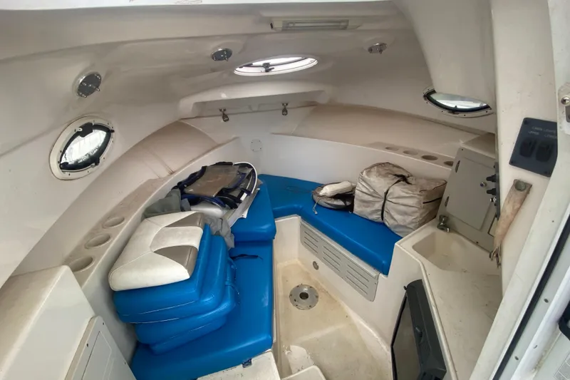 Slide: The Image of Interior of a 2006 Polar 2300 Walkaround boat with blue seating and storage. - 18