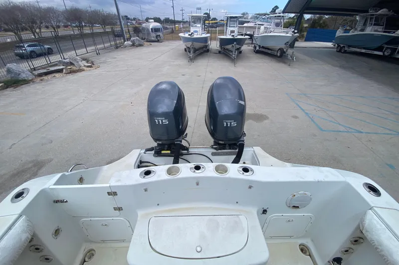 Slide: The Image of 2006 Polar 2300 Walkaround boat with dual Yamaha 115 engines in a boatyard. - 21