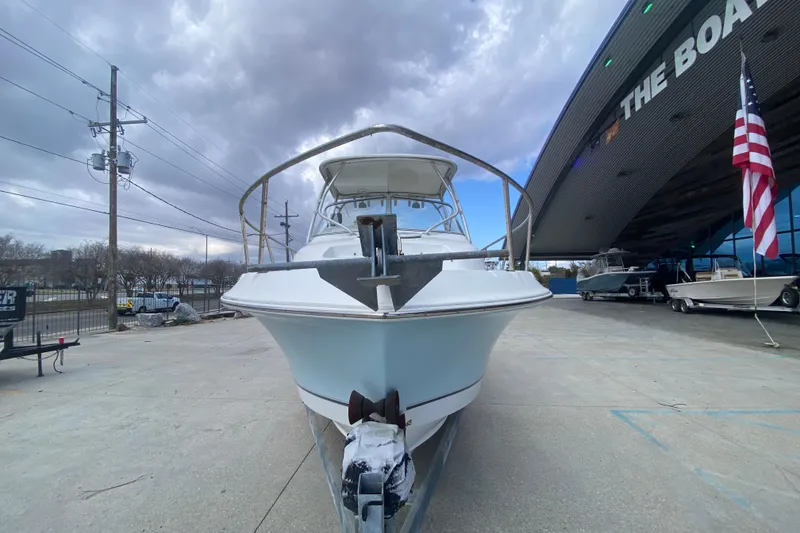 Slide: The Image of 2006 Polar 2300 Walkaround boat displayed outdoors near a showroom with an American flag. - 8