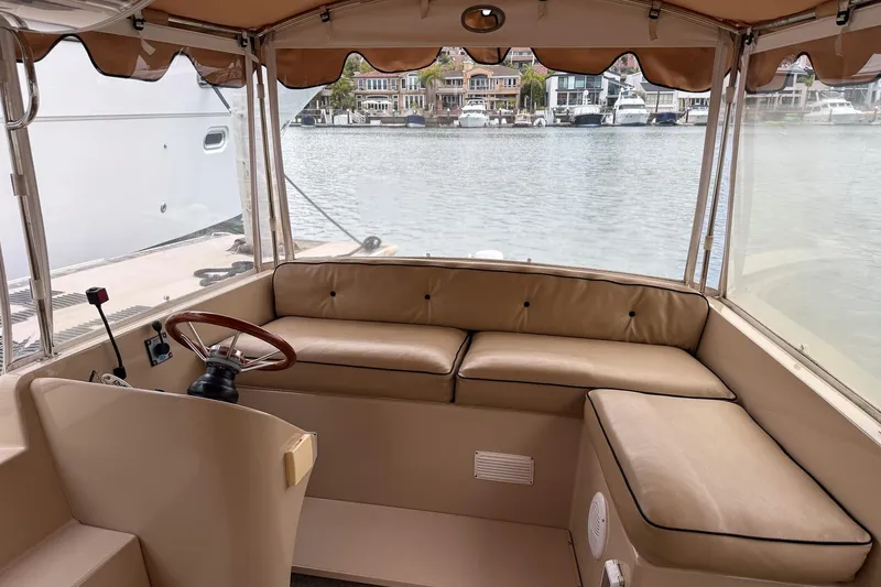 Slide: The Image of 2007 Duffield Cutty Cabin interior with tan seating, steering wheel, and waterfront view. - 5