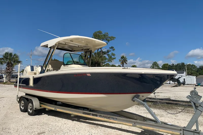 The Image of 2019 Chris-Craft Catalina 27 boat on trailer, parked outdoors under clear blue sky. - 1