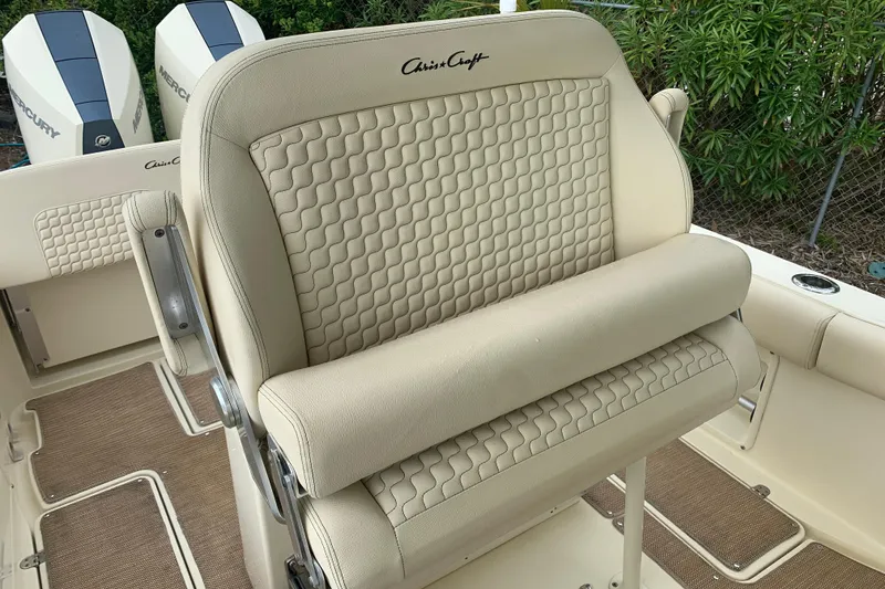 Slide: The Image of 2019 Chris-Craft Catalina 27 boat interior with beige quilted seating and dual Mercury engines. - 12