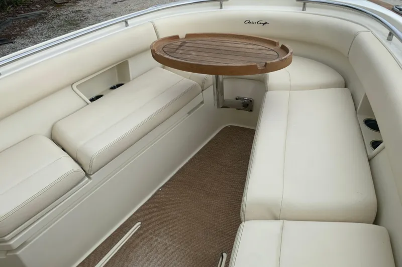 Slide: The Image of 2019 Chris-Craft Catalina 27 interior with cushioned seating and wooden table. - 25