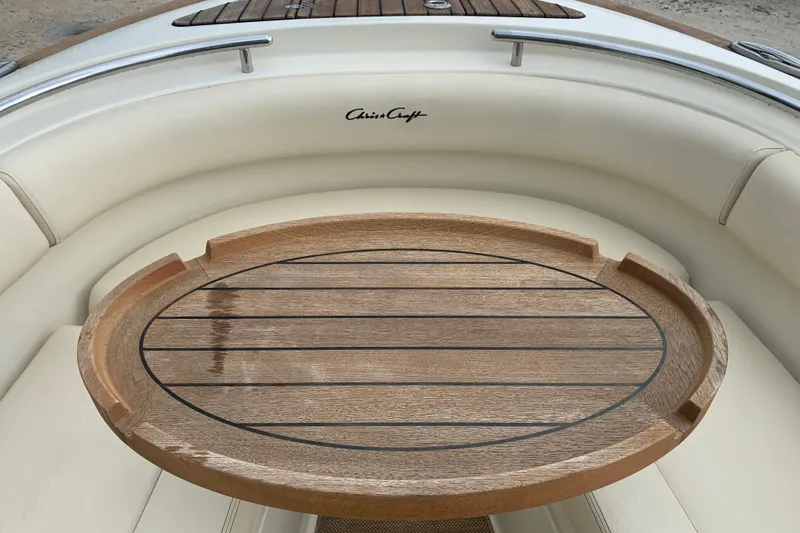 Slide: The Image of 2019 Chris-Craft Catalina 27 interior with wooden table and cushioned seating. - 26