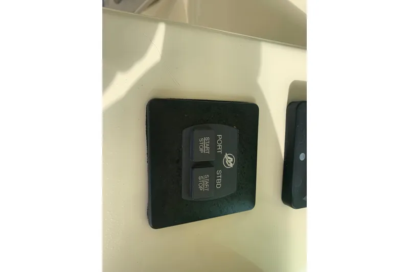 Slide: The Image of Control panel of a 2019 Chris-Craft Catalina 27 boat, featuring start and stop buttons. - 28